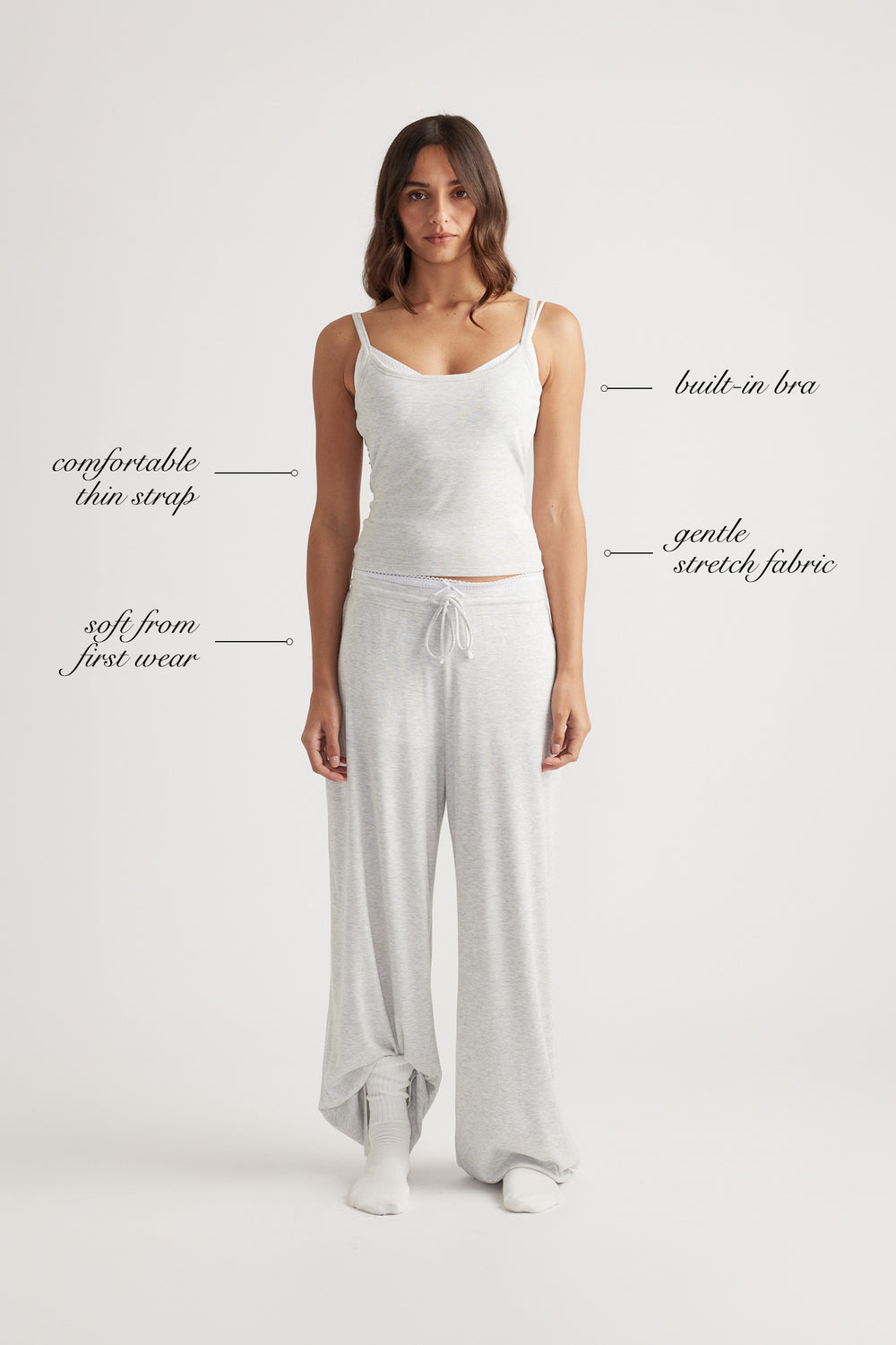 Woman wearing light grey ribbed cami with built-in bra and matching wide leg lounge pants with drawstring waist