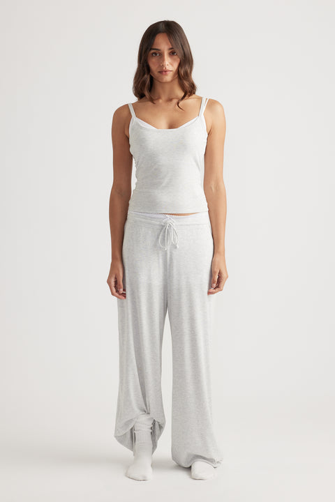 Woman wearing light grey ribbed camisole top paired with matching wide leg pants for soft loungewear comfort