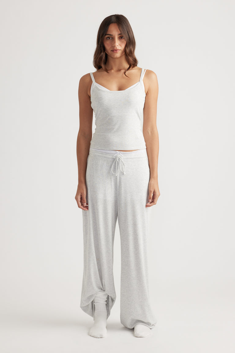 Woman wearing light grey ribbed camisole top paired with matching wide leg pants for soft loungewear comfort
