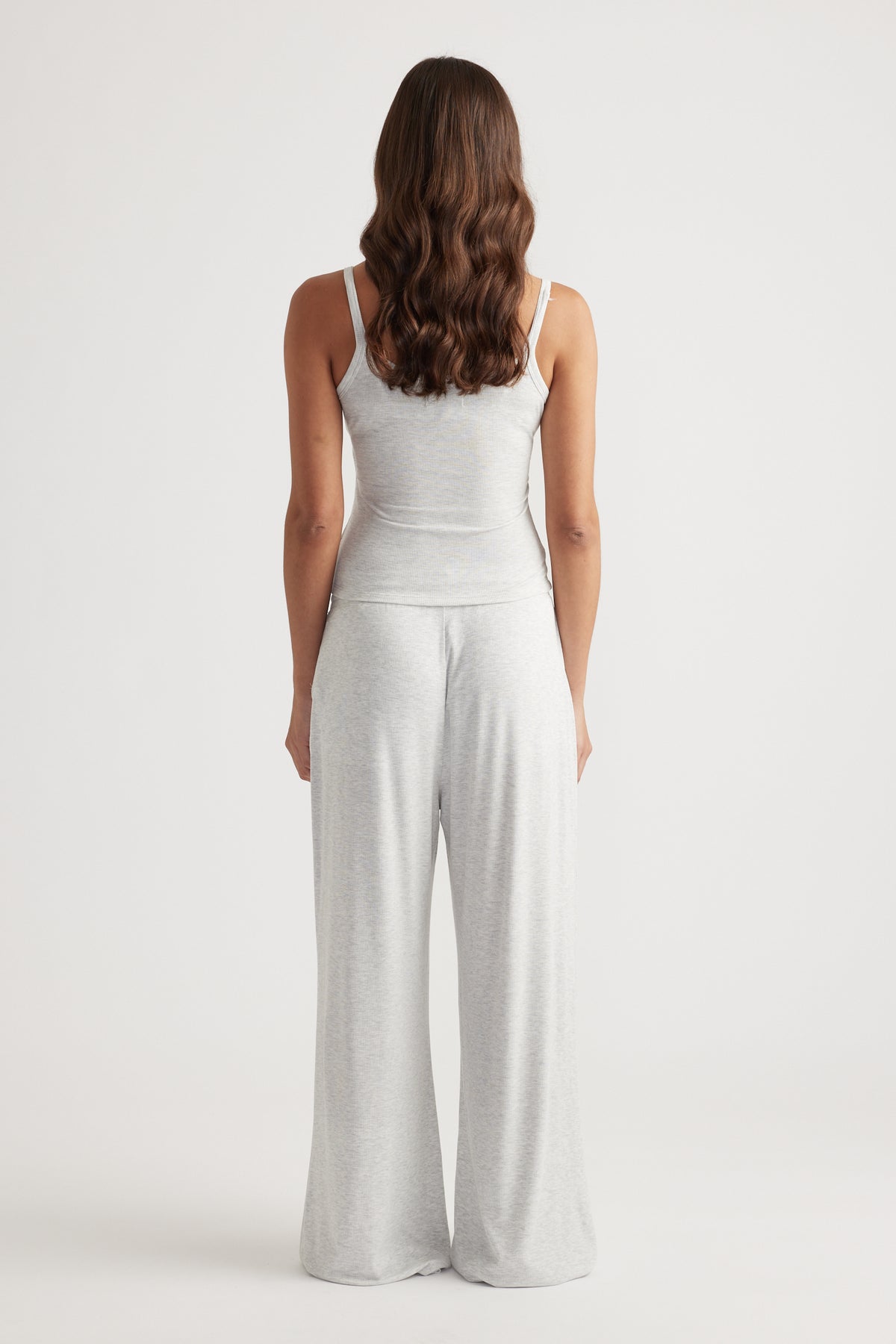 Woman wearing light grey ribbed cami top paired with loose wide leg pants in soft, breathable fabric for relaxed style