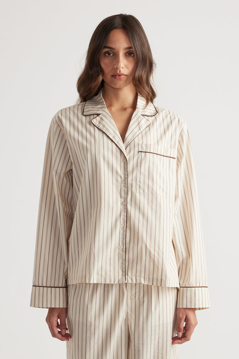 Woman wearing cream and brown striped sleep woven long sleeve shirt with matching relaxed pants in soft fabric
