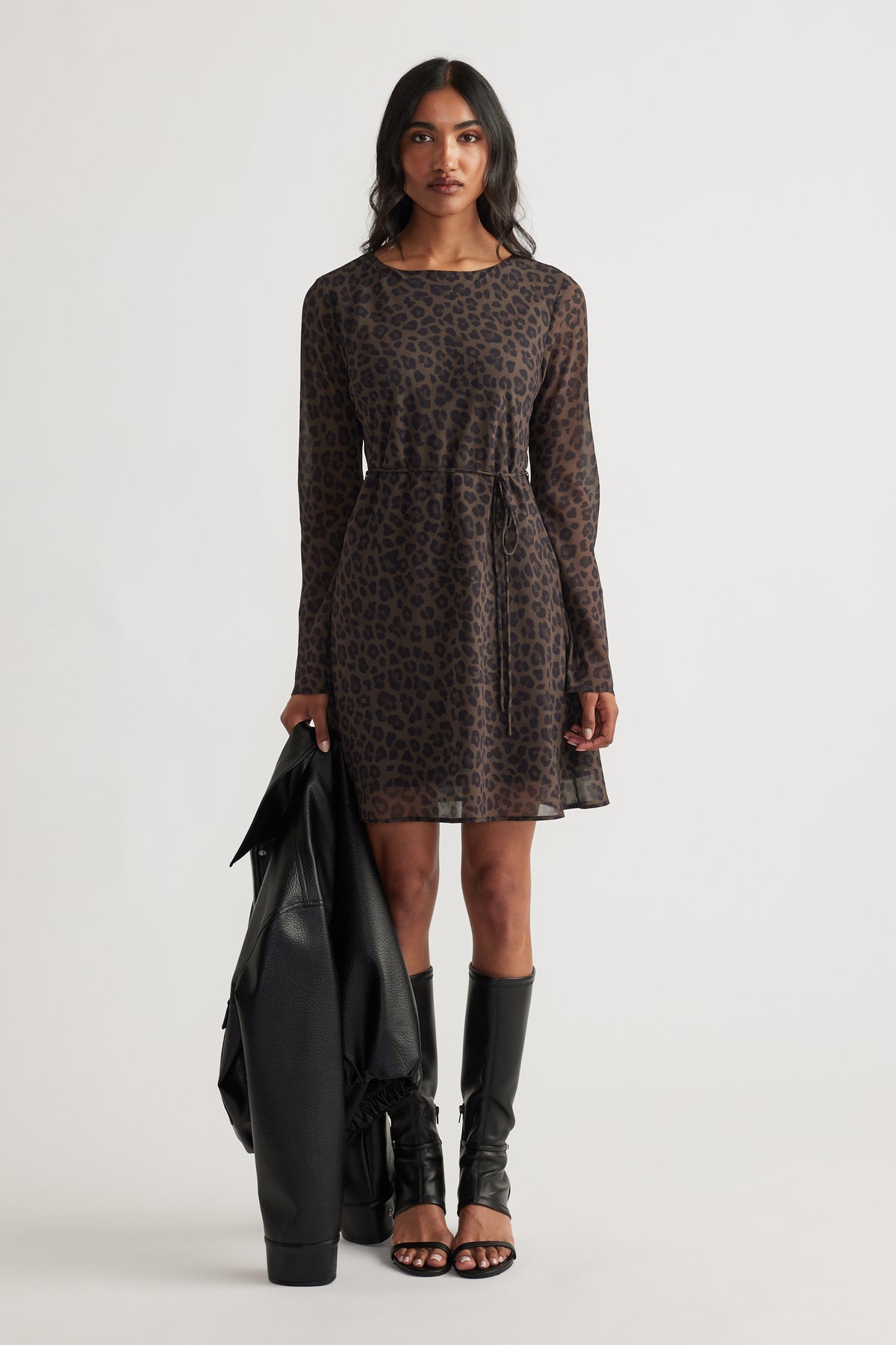 Chelsea Georgette Mini Dress in dark animal print with long sleeves, relaxed waist, styled with black boots and jacket by DECJUBA