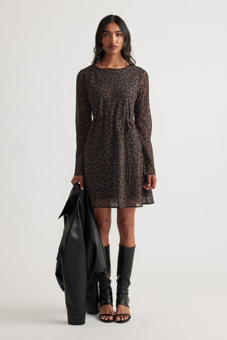 Chelsea Georgette Mini Dress in dark animal print with long sleeves, relaxed waist, styled with black boots and jacket by DECJUBA
