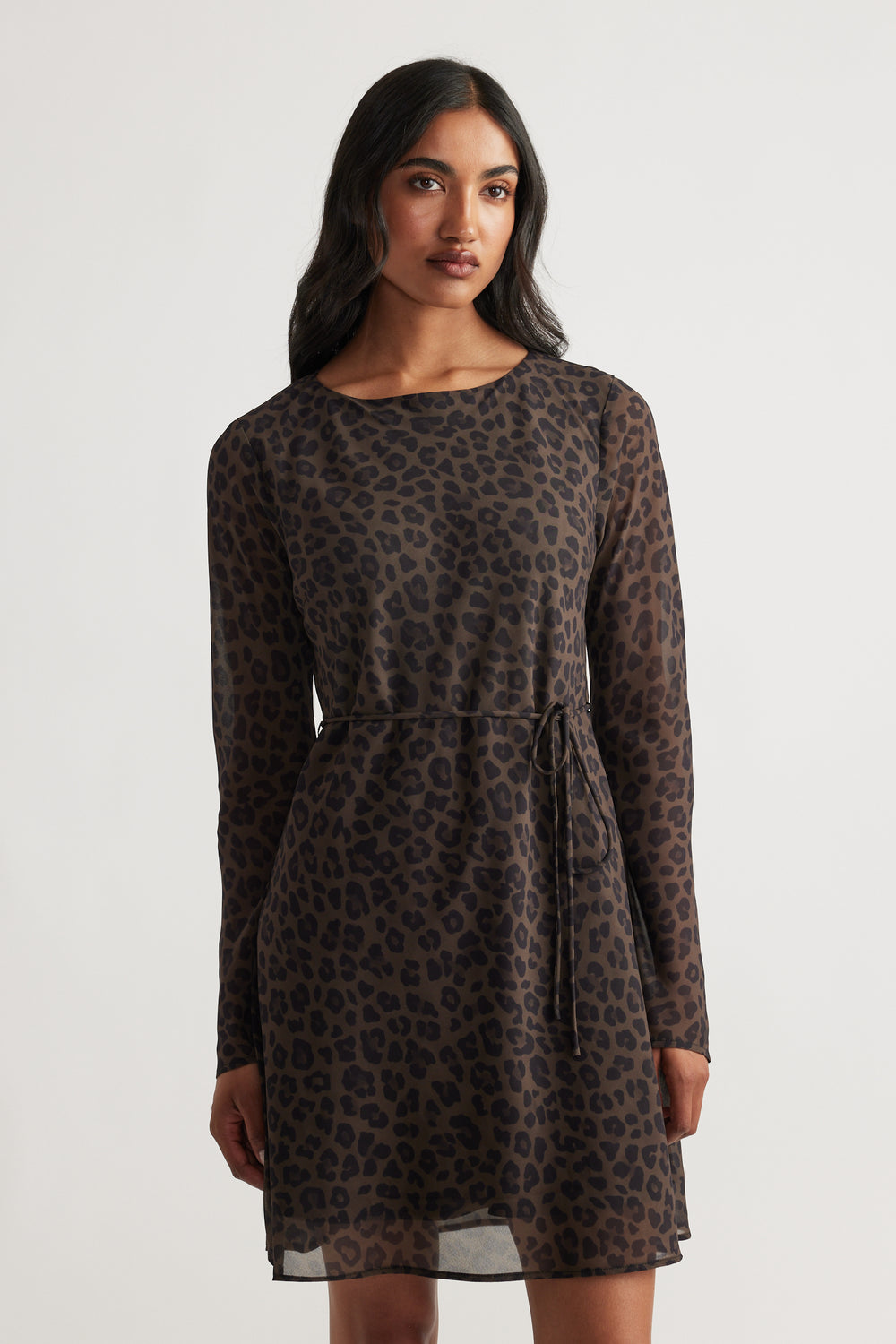 Woman wearing Chelsea Georgette Mini Dress in muted khaki with long sleeves and subtle leopard print for a refined look