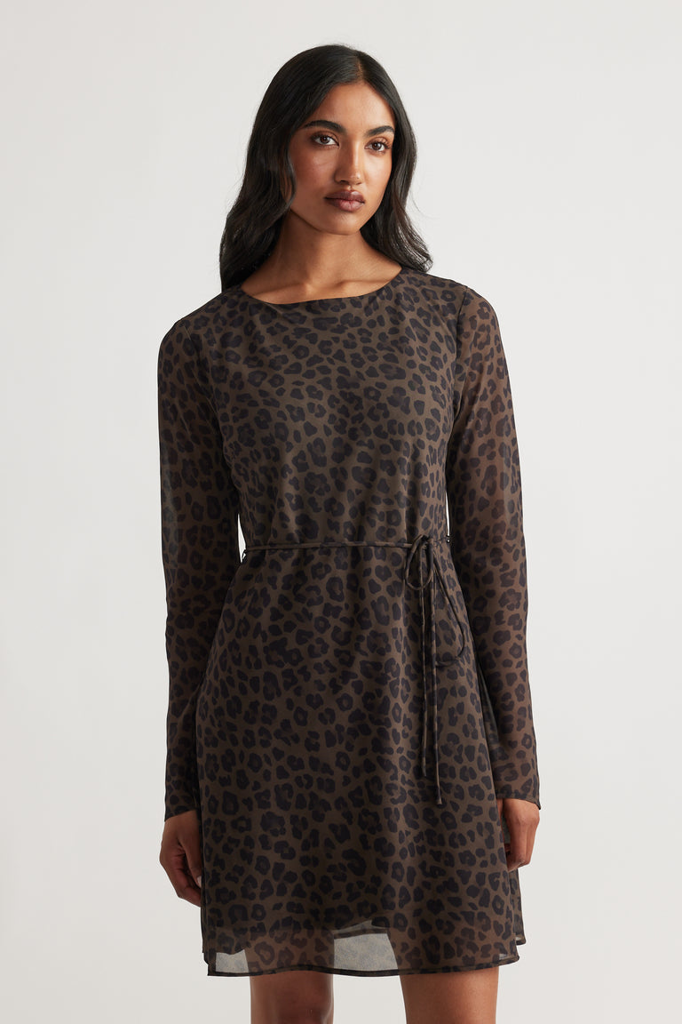 Woman wearing Chelsea Georgette Mini Dress in muted khaki with long sleeves and subtle leopard print for a refined look