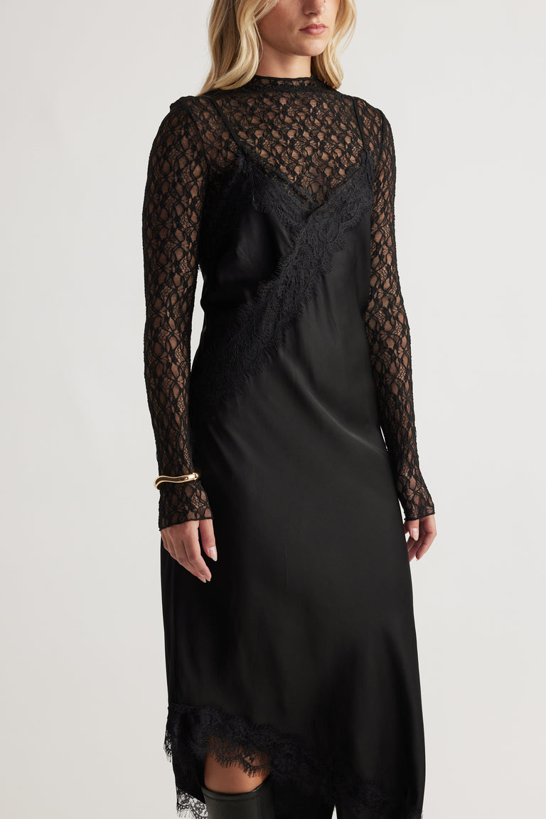 Woman wearing a black Karla Lace Midi Dress with lace long sleeves and delicate lace trim for a chic, elegant look