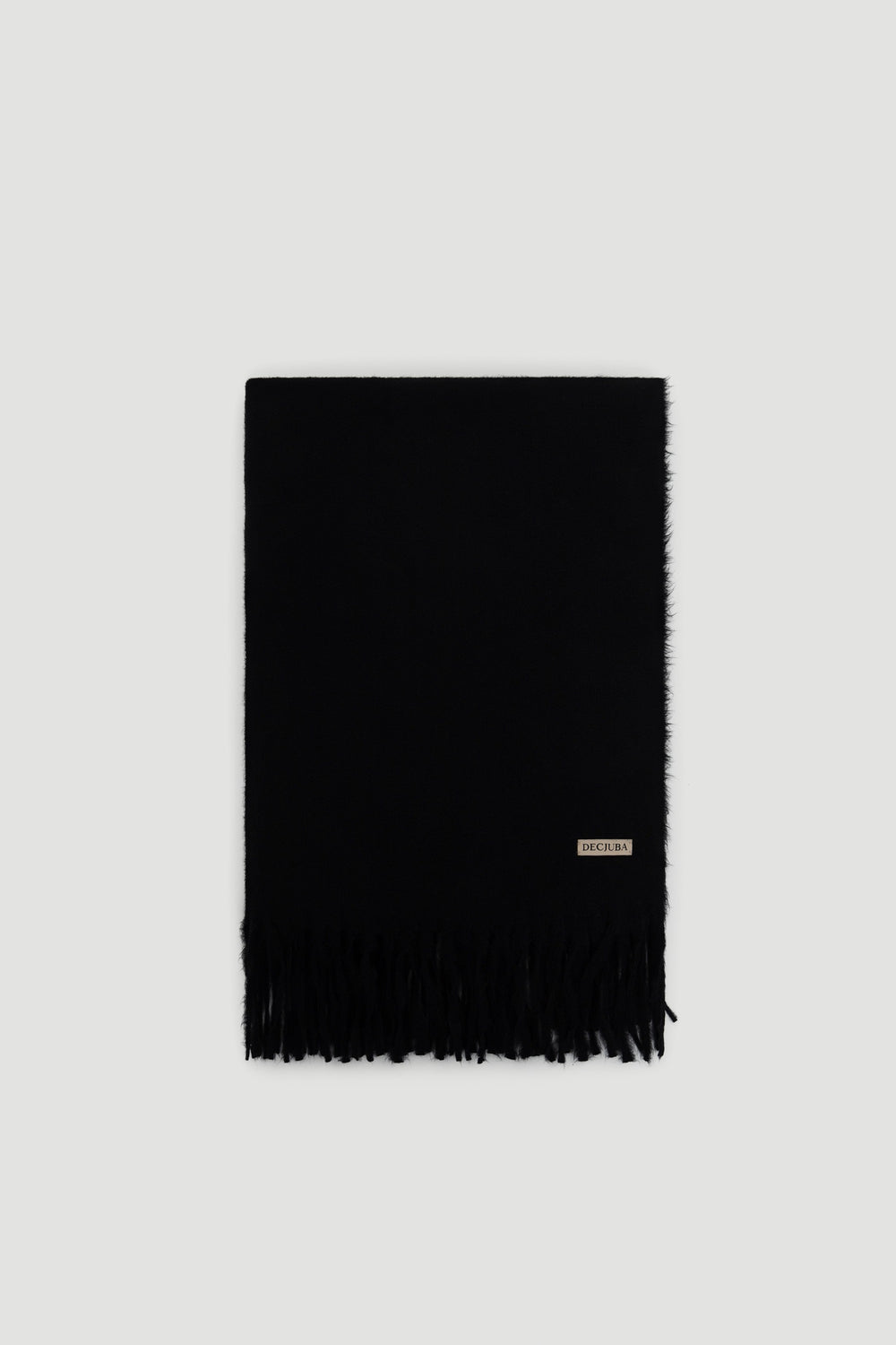 Black soft scarf with subtle fringe detailing and a small branded tag near the edge for a sleek finish