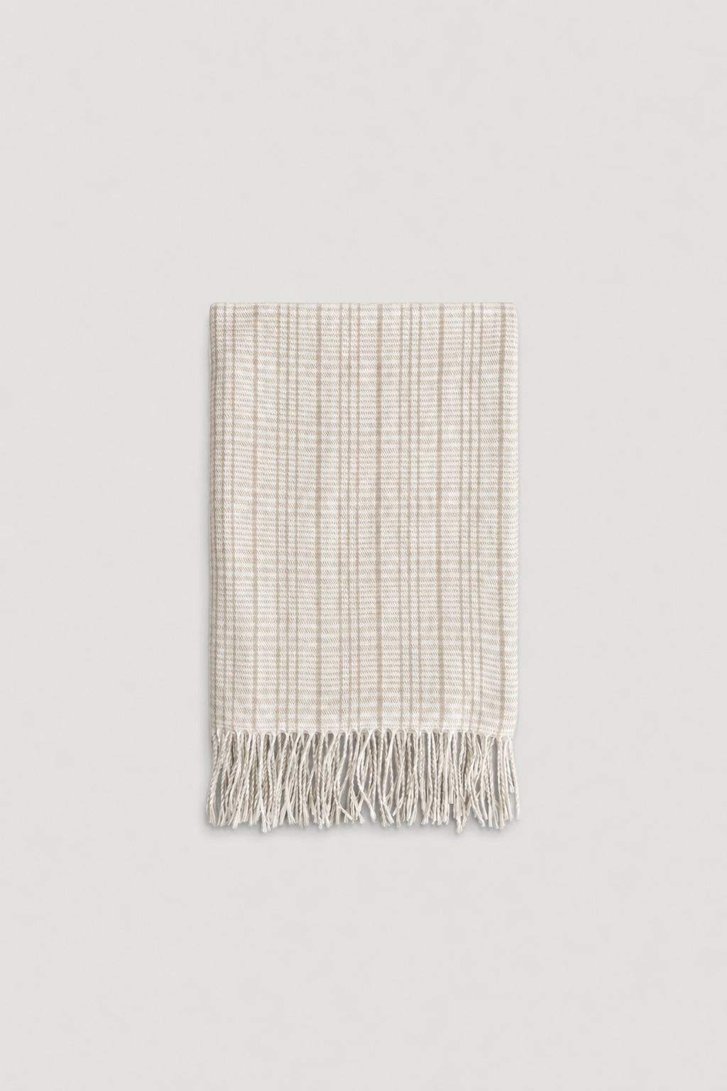 Light beige check patterned scarf with soft texture and delicate fringe edges for a cozy, stylish touch