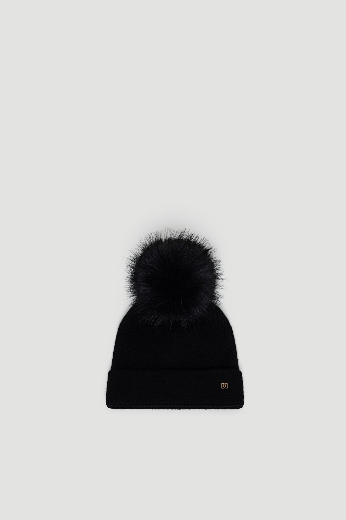 Black Demi Pom Beanie with a fluffy pom-pom and cuffed edge, designed for cozy, stylish winter wear by DECJUBA.