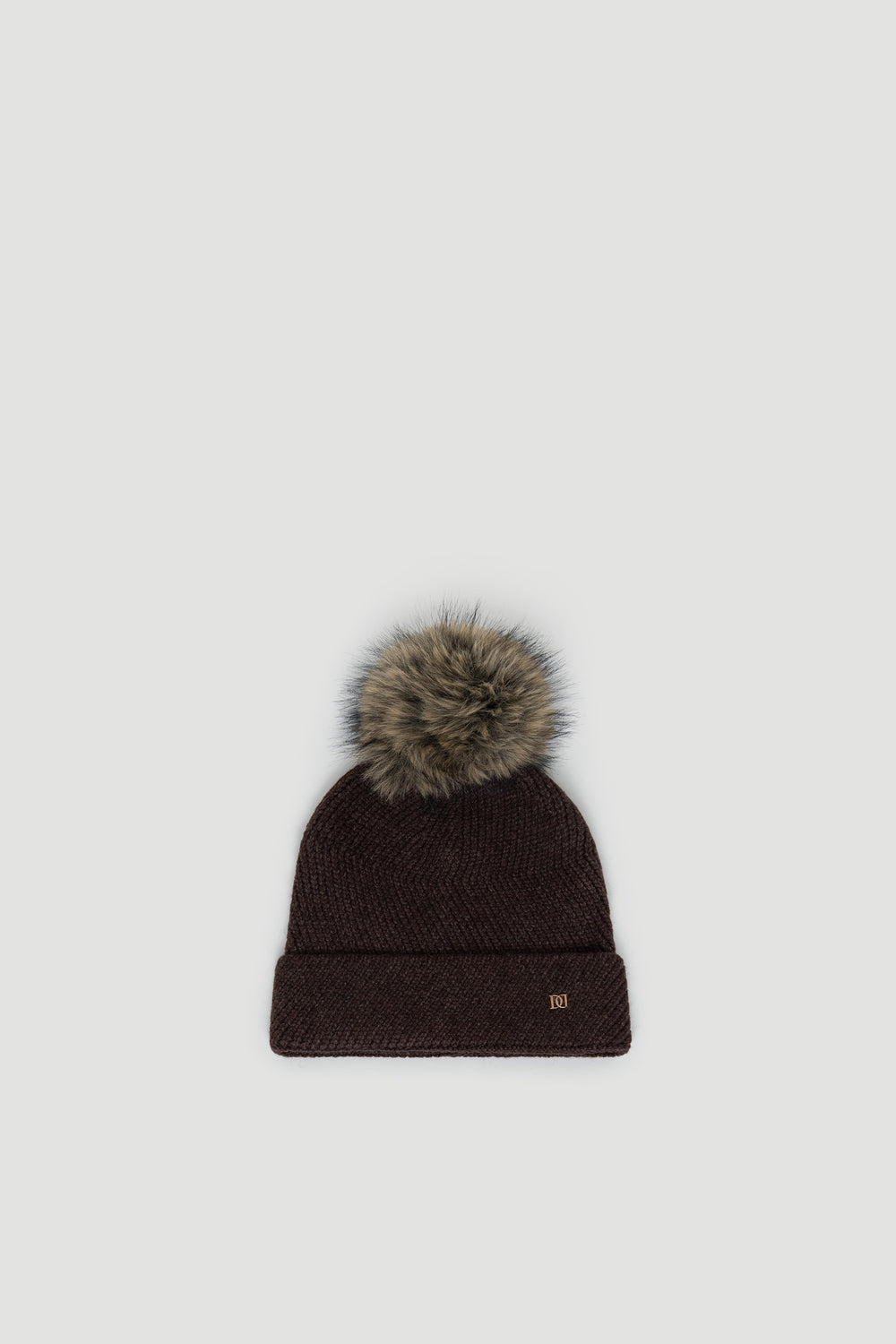 Dark chocolate knit beanie with a fluffy faux fur pom pom and subtle gold-tone logo detail on cuff.