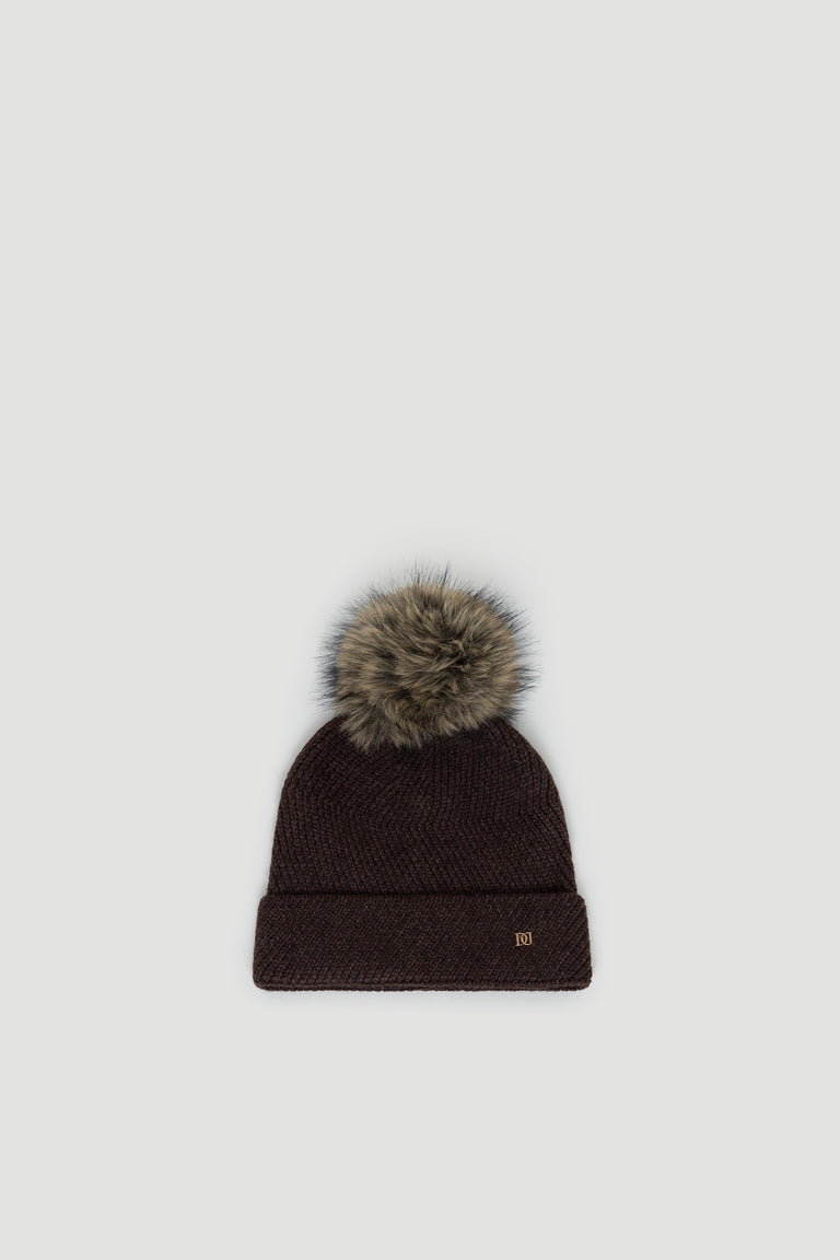 Dark chocolate knit beanie with a fluffy faux fur pom pom and subtle gold-tone logo detail on cuff.