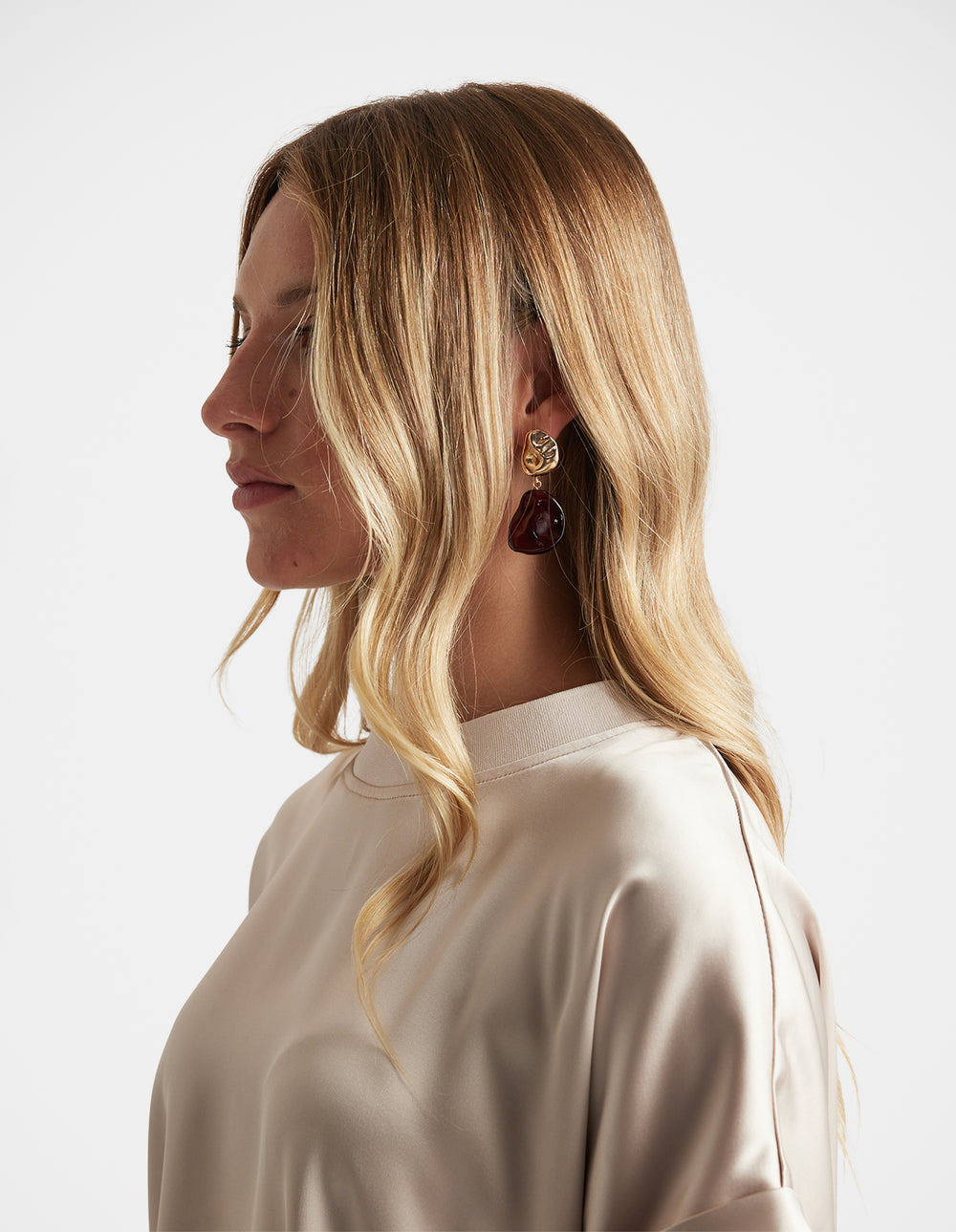 Side profile of woman wearing Millie Stone Teardrop Earring with gold detail and deep red stone by DECJUBA Australian brand