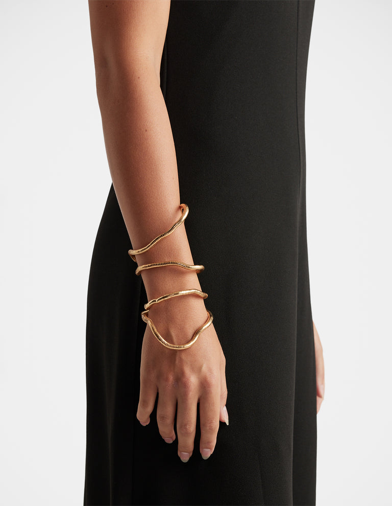 Maya Wrap Bracelet in polished gold-tone featuring fluid layered design, effortlessly elegant by DECJUBA Australian fashion brand