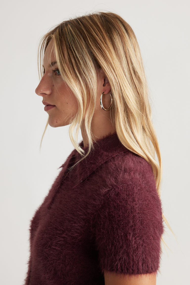 Ellie Classic Hoop Earrings in polished silver worn by a woman with blonde hair and a soft burgundy knit top by DECJUBA.