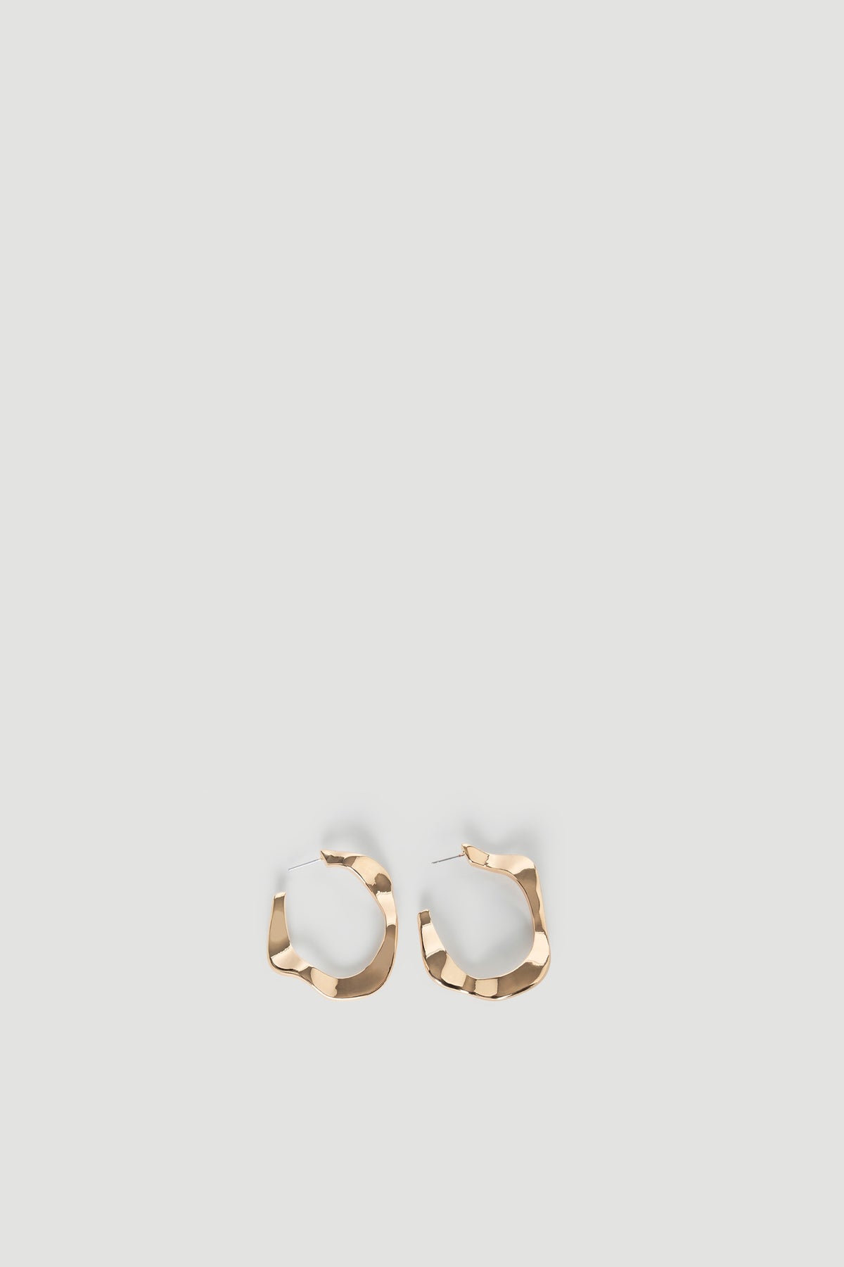 Pair of gold-tone Evelyn Wavy Hoop Earrings with textured, irregular shape for a modern, stylish look by DECJUBA.