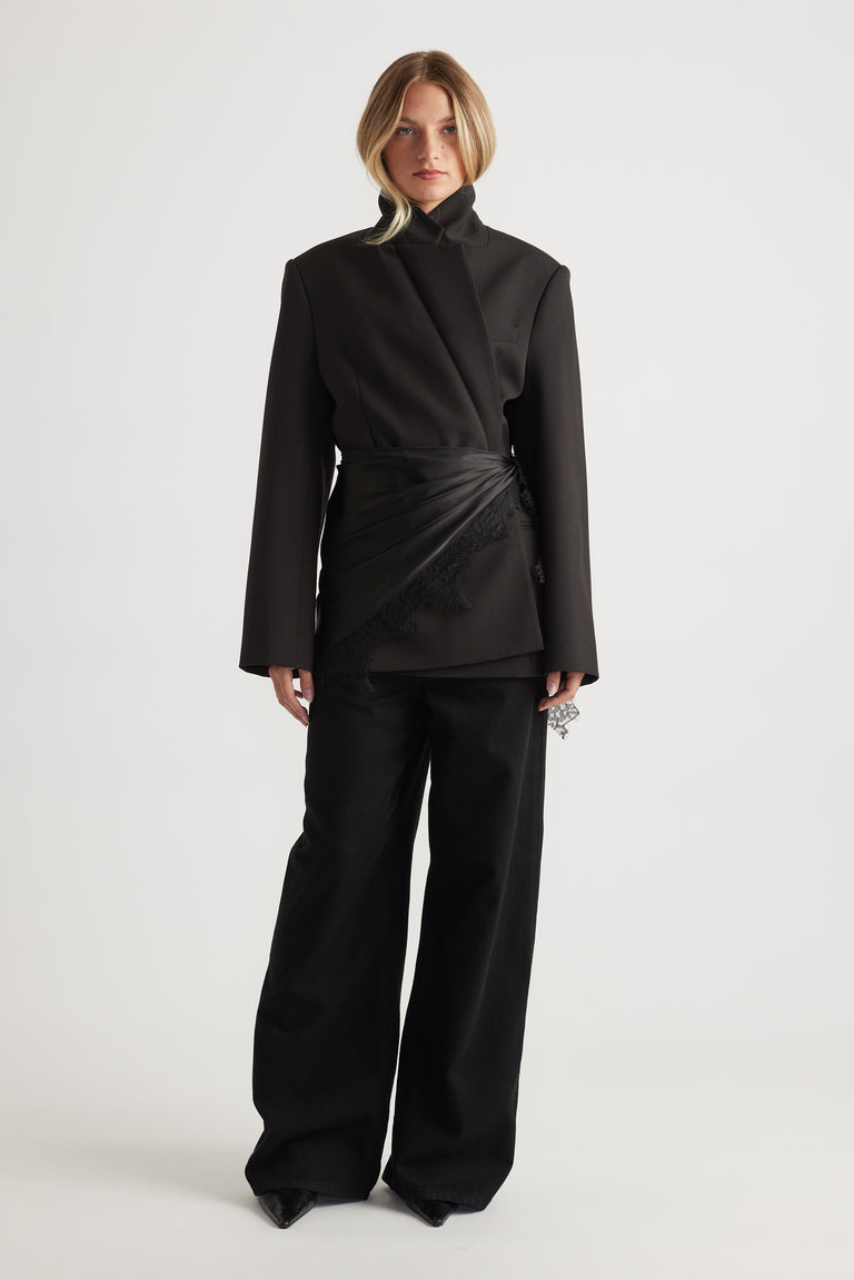 Woman wearing black tailored blazer and wide-leg pants styled with layered Sienna Lace Scarf by DECJUBA.