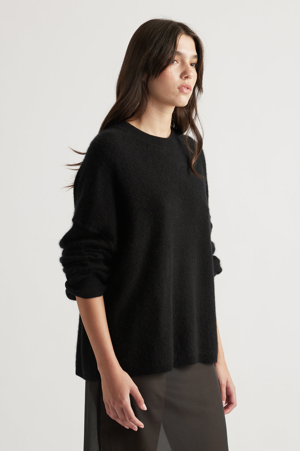 Woman wearing a cozy oversized black wool knit with long sleeves and relaxed fit, styled in a minimalistic look