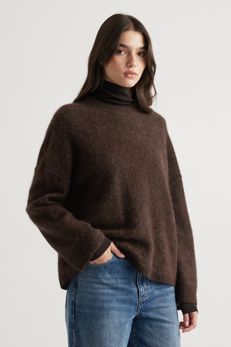Woman wearing a cozy chocolate brown oversized wool knit paired with faded blue jeans for a relaxed look