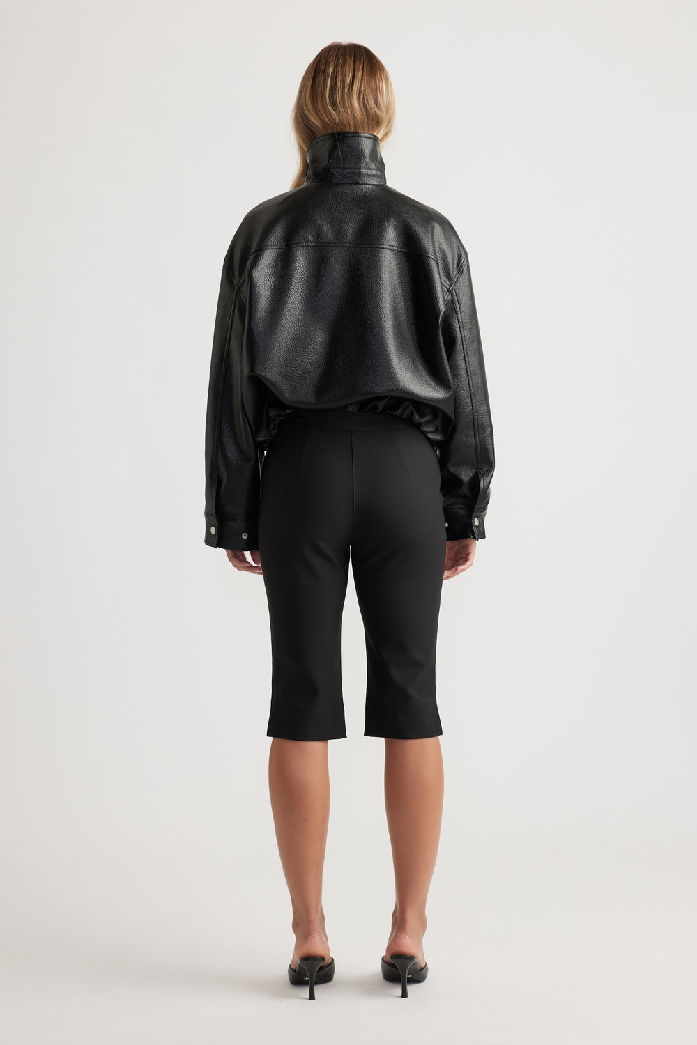 Back view of woman wearing Melanie Capri Pant in black with tailored fit by Decjuba Australian fashion brand