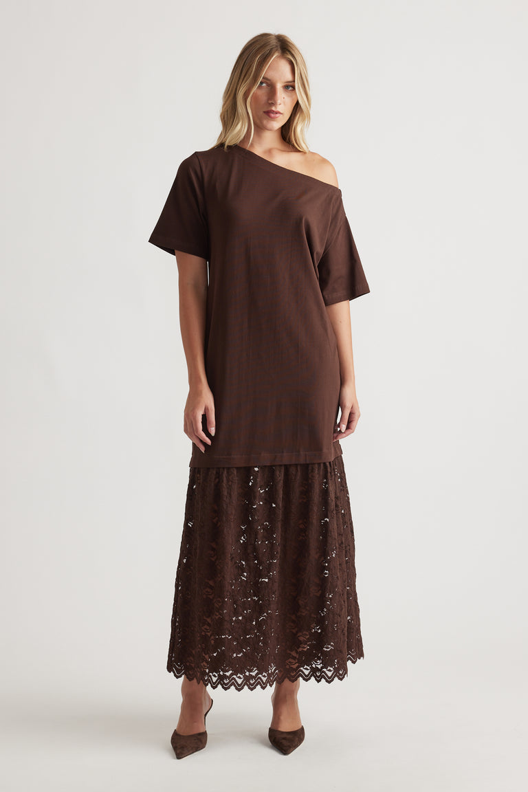 Woman wearing Alexis Lace Maxi Dress in rich chocolate brown featuring an off-shoulder top and intricate lace skirt by DECJUBA