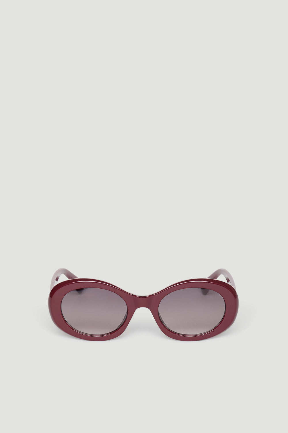 Rounded sunglasses with glossy burgundy frame and gradient tinted lenses for a chic, modern look