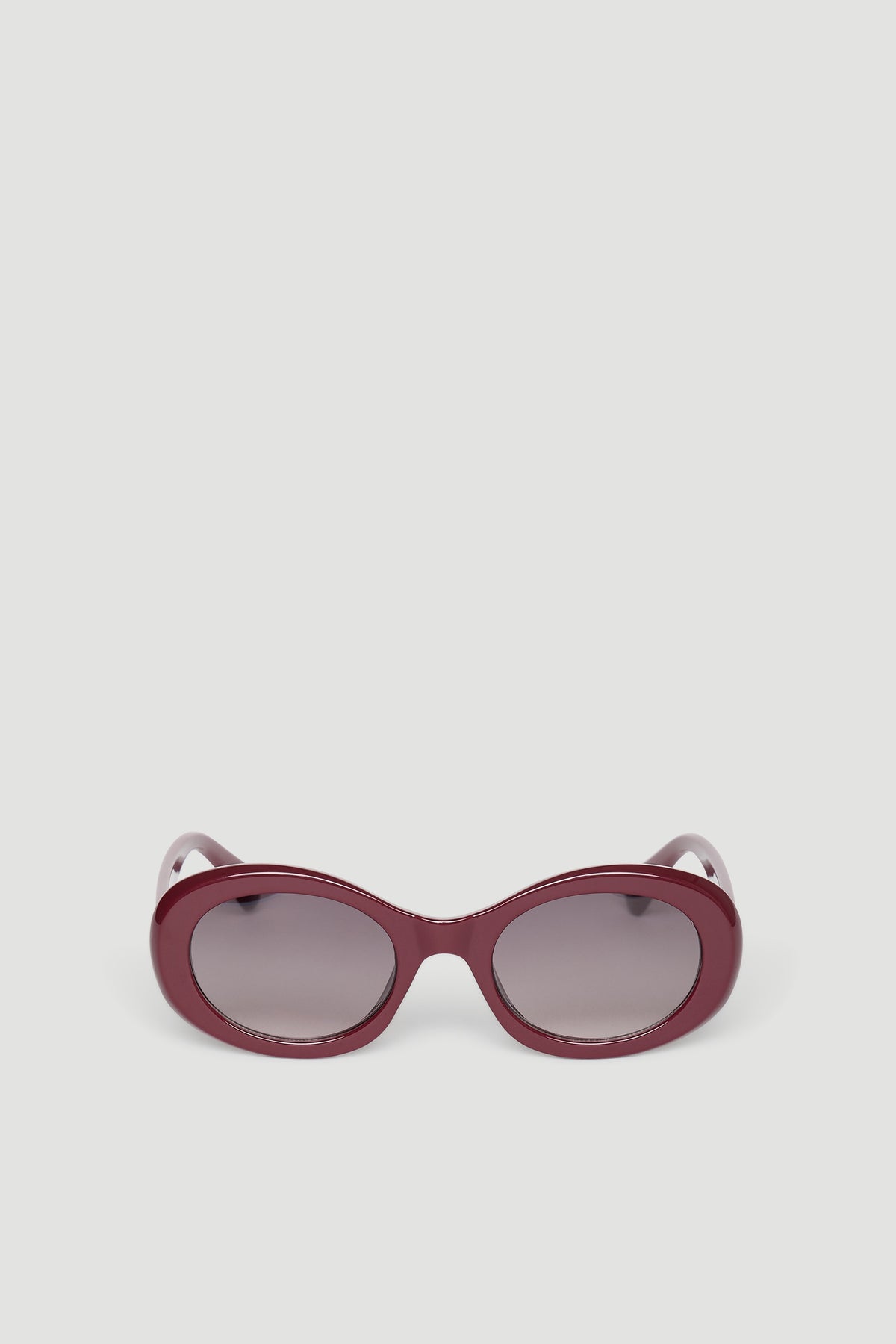 Rounded sunglasses with glossy burgundy frame and gradient tinted lenses for a chic, modern look