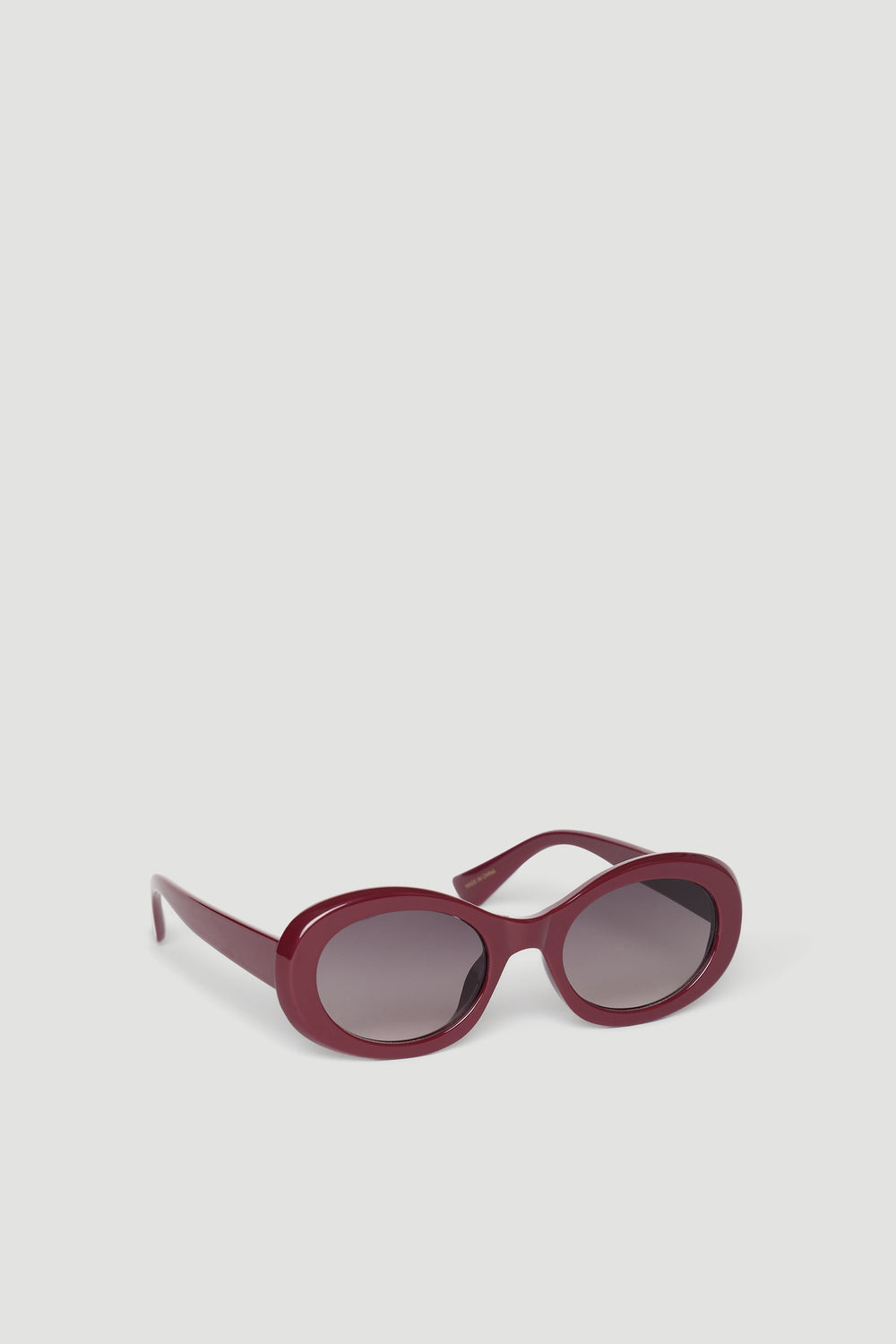 Stylish burgundy rounded sunglasses with dark tinted lenses designed for a chic, effortless look.