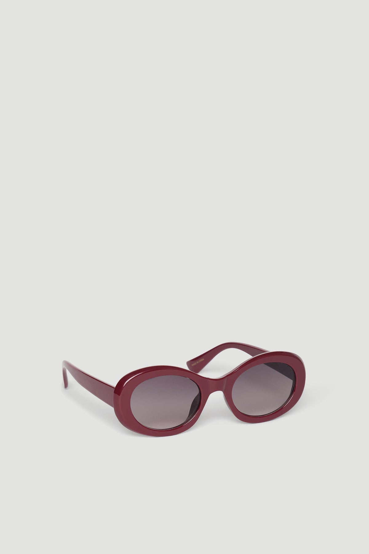 Stylish burgundy rounded sunglasses with dark tinted lenses designed for a chic, effortless look.