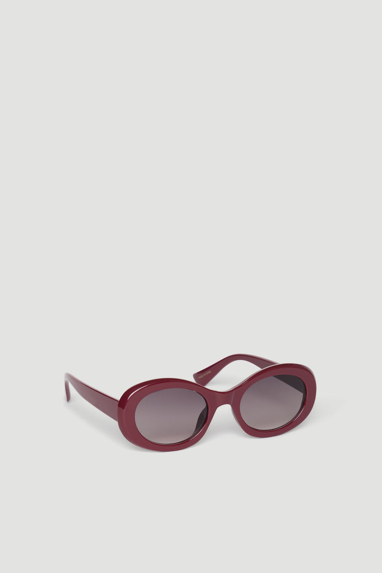 Stylish burgundy rounded sunglasses with dark tinted lenses designed for a chic, effortless look.