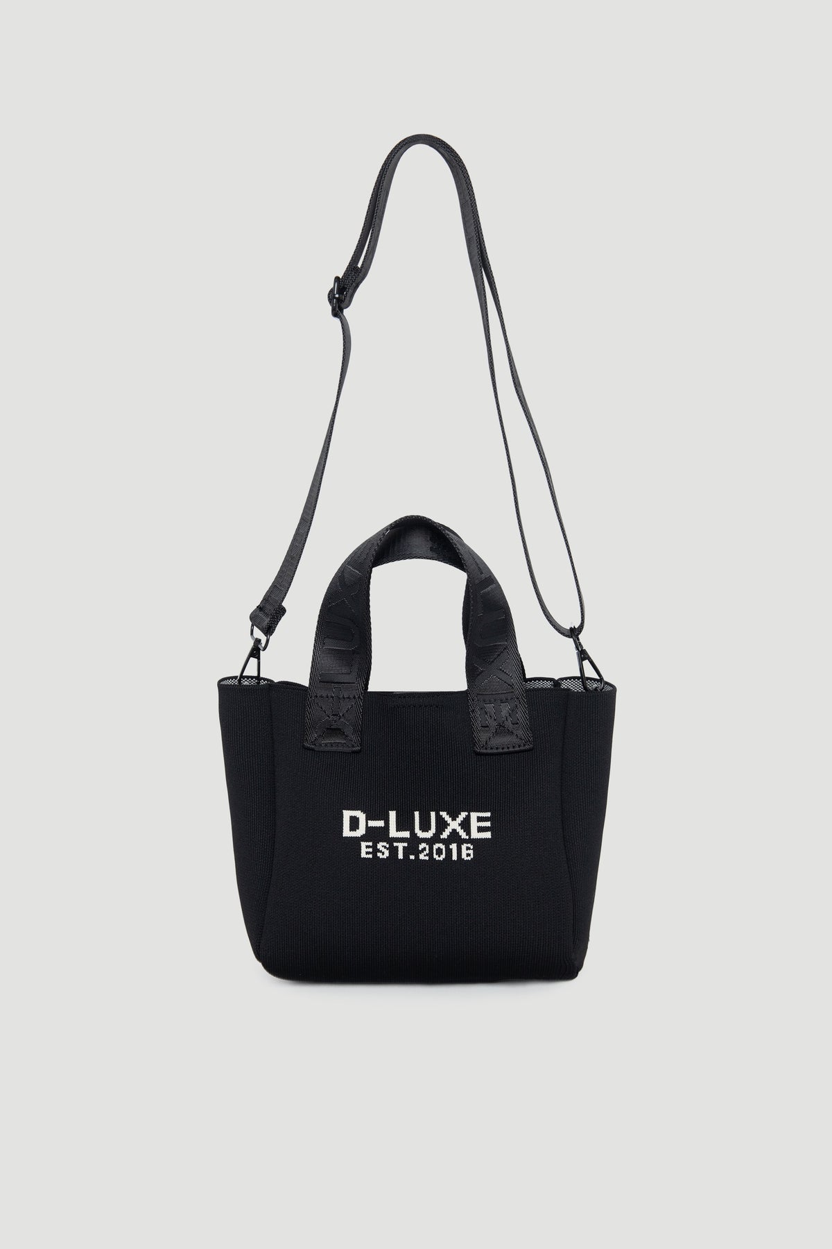 Black mini tote with top handles, adjustable shoulder strap, and white embroidered logo detail on front.