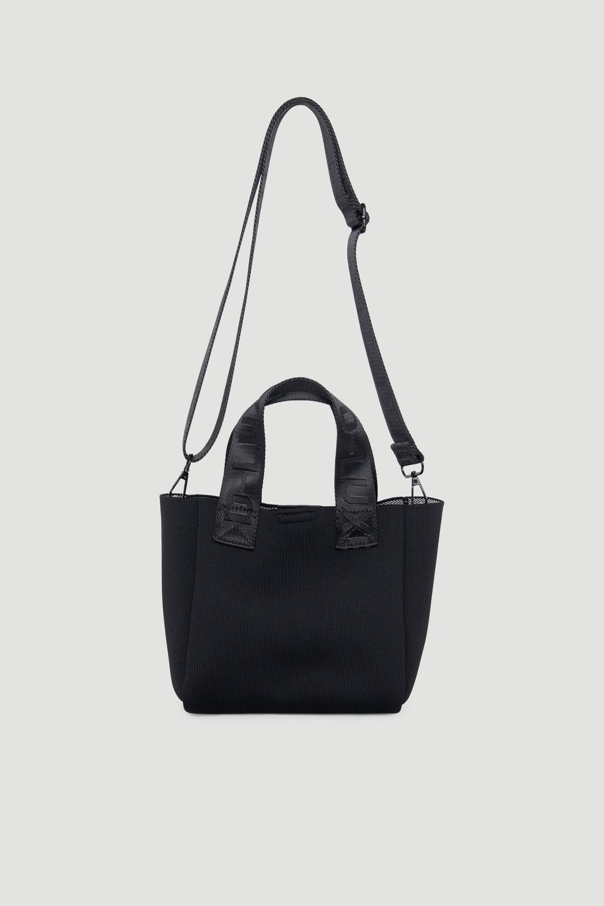 Compact black mini tote bag with dual handles and adjustable shoulder strap for versatile wear