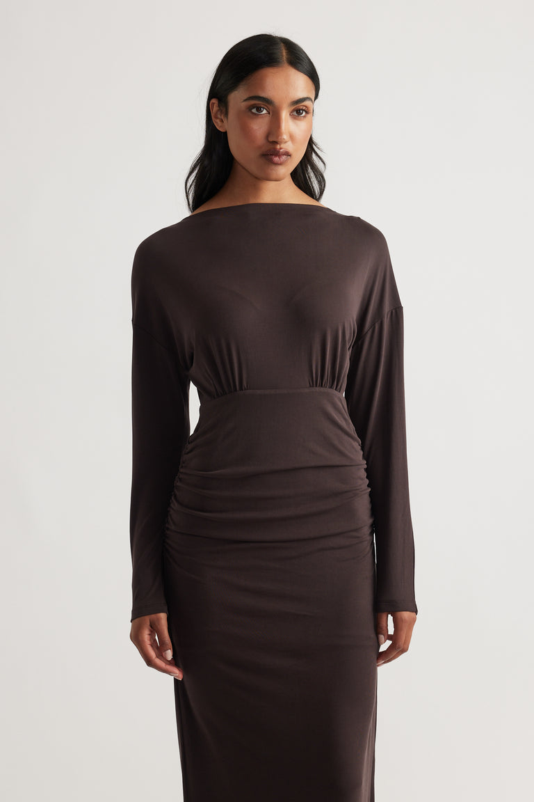 Woman wearing Tahlia Cinched Maxi Dress in rich cedar brown with long sleeves and fitted waist by DECJUBA.