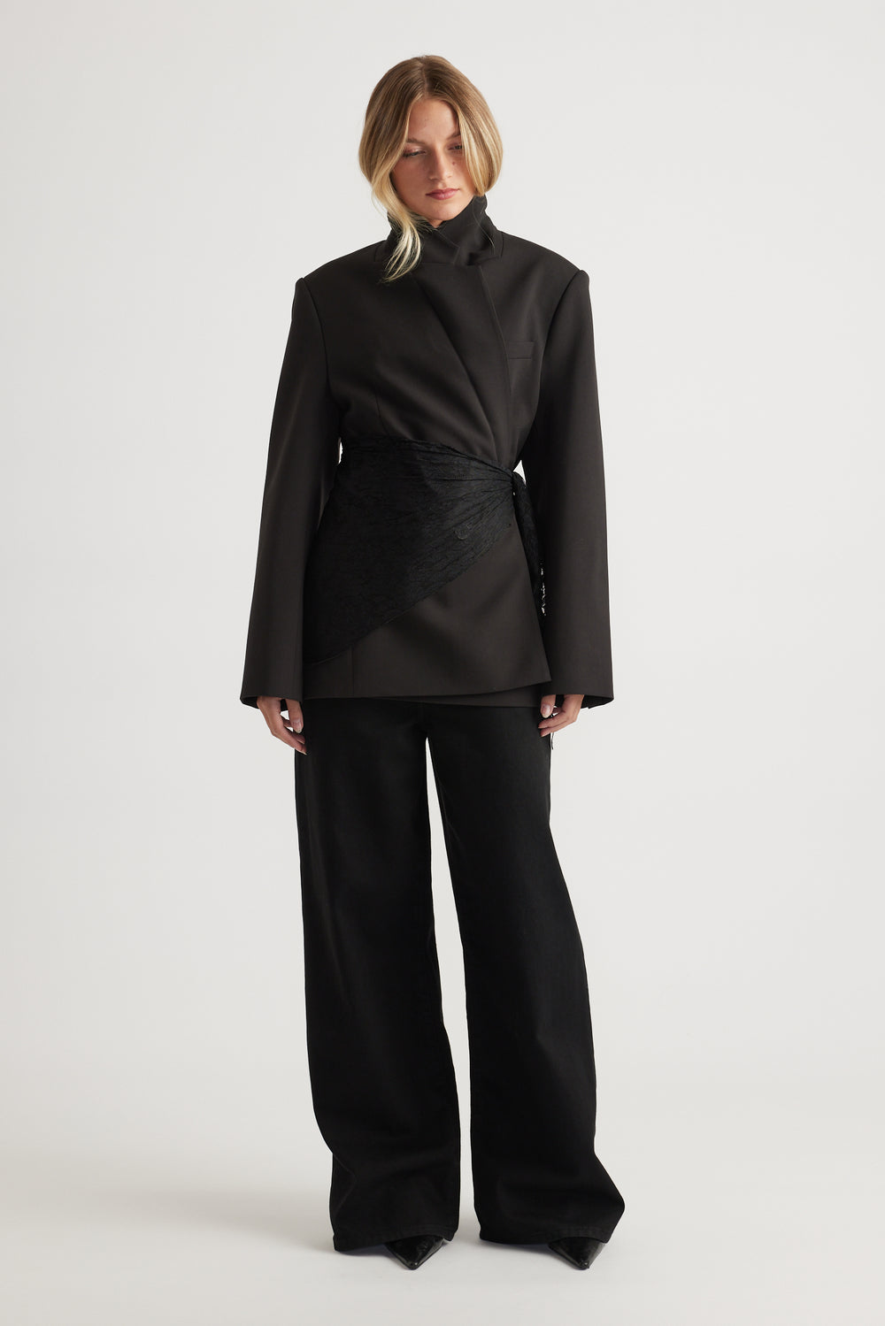 Woman wearing black oversized blazer styled with Penny Lace Scarf wrapped at the waist and wide-leg pants by DECJUBA.