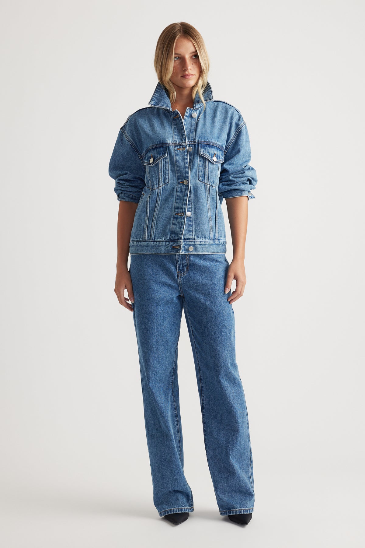 Nakita Denim Jacket in medium blue denim with relaxed fit and rolled sleeves styled with wide-leg jeans by Decjuba Australian brand