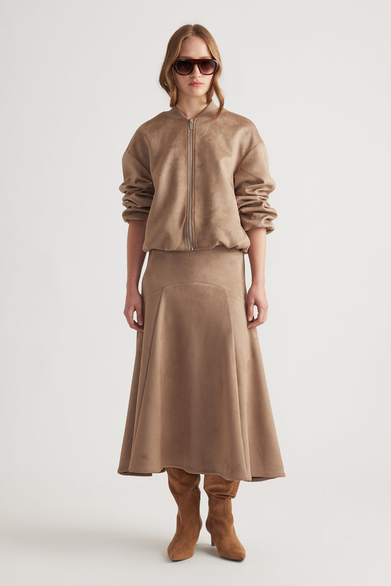 Model wearing a soft dove grey faux suede midi skirt with matching zip-up jacket and suede knee-high boots
