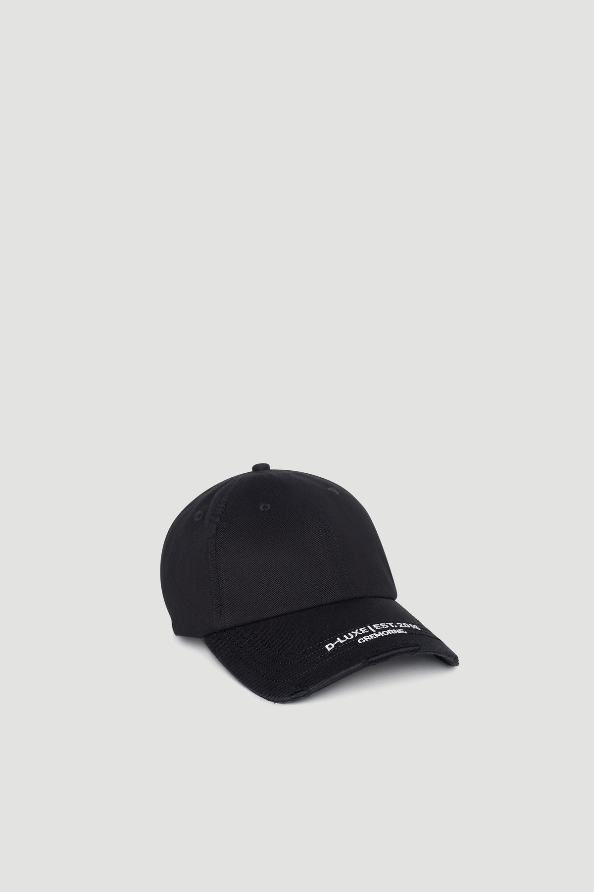 Black distressed cap with curved brim featuring subtle white embroidered logo detail on front edge