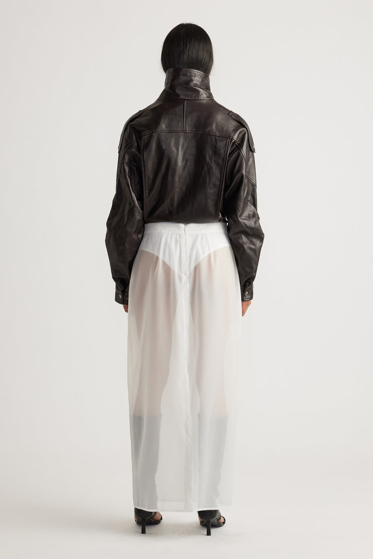 Back view of a sheer ivory organza maxi skirt layered over fitted shorts, styled with a cropped black leather jacket