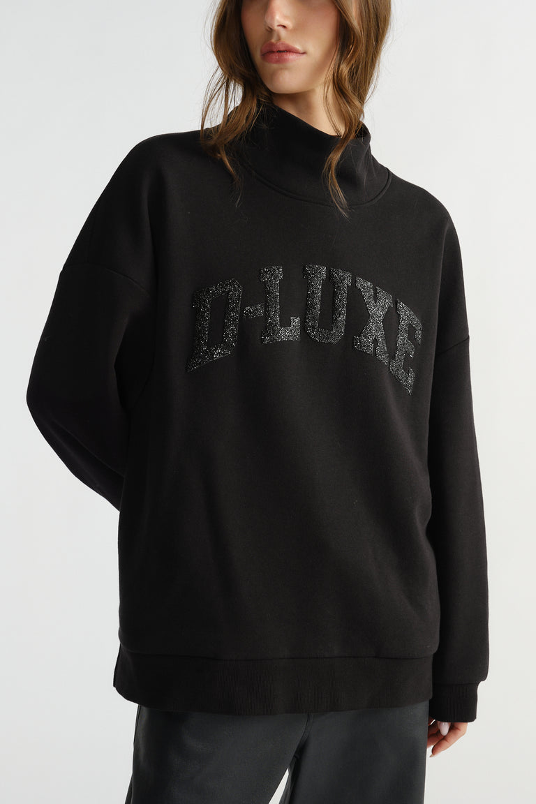 Woman wearing a black mock neck sweat with subtle sparkle lettering for a stylish, comfortable everyday look