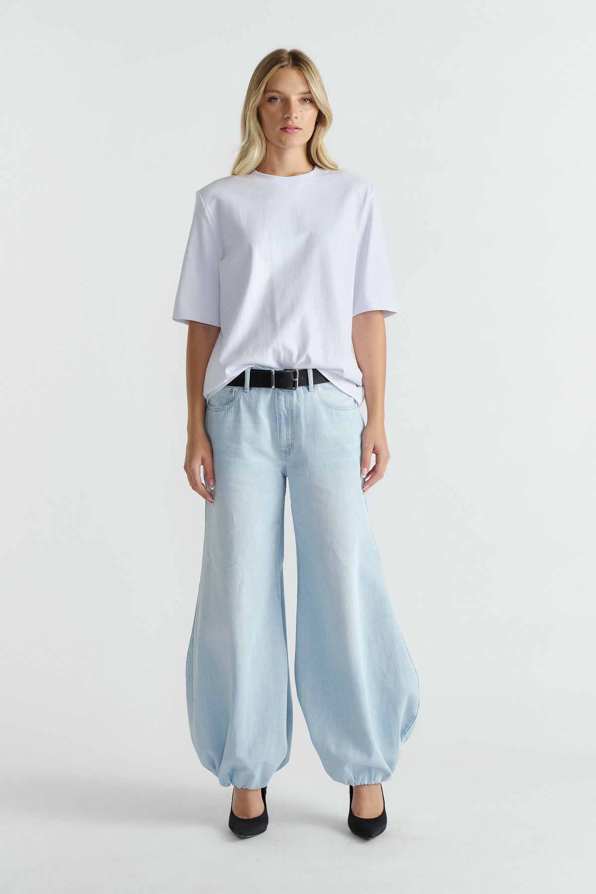 Woman wearing light wash high-rise balloon jeans paired with a relaxed white tee and black belt for casual style.