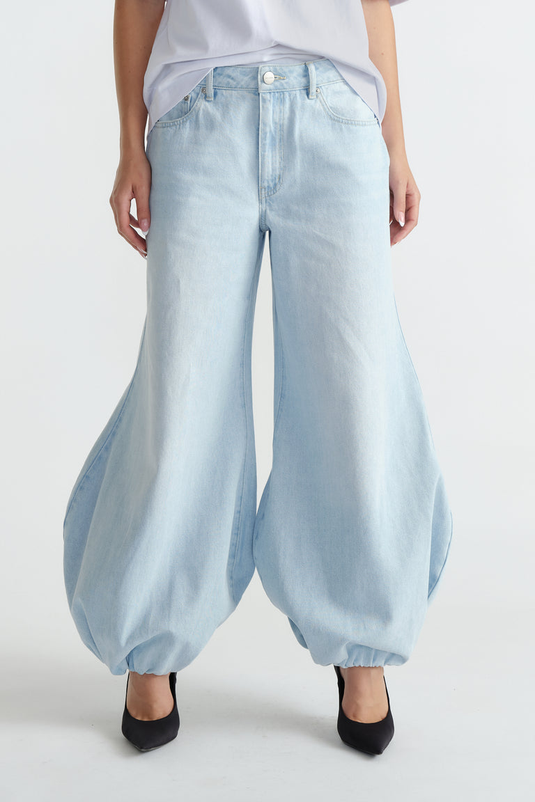Light wash high-rise balloon jeans with a loose, tapered fit cinched at the ankles for a stylish statement look.