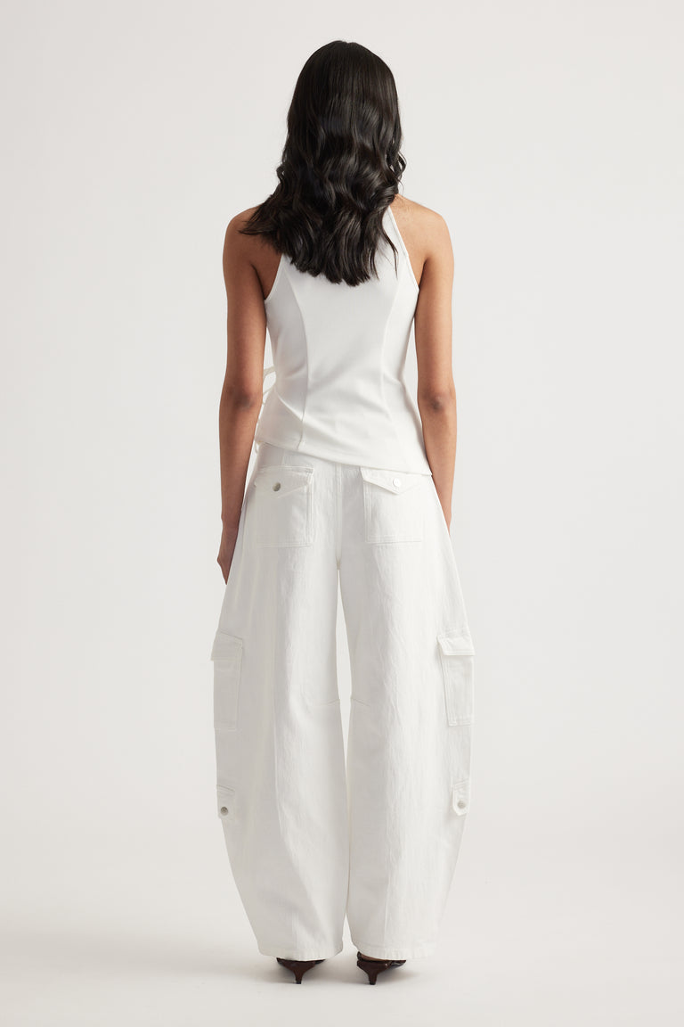 Back view of woman wearing a white sleeveless halter top with wide leg cargo pants and heels