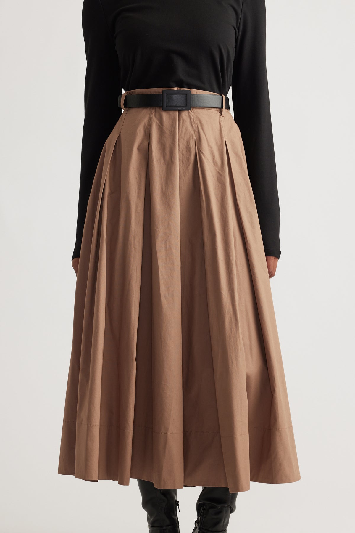 High-waisted pleated midi skirt in warm brown styled with a fitted black long-sleeve top and black belt
