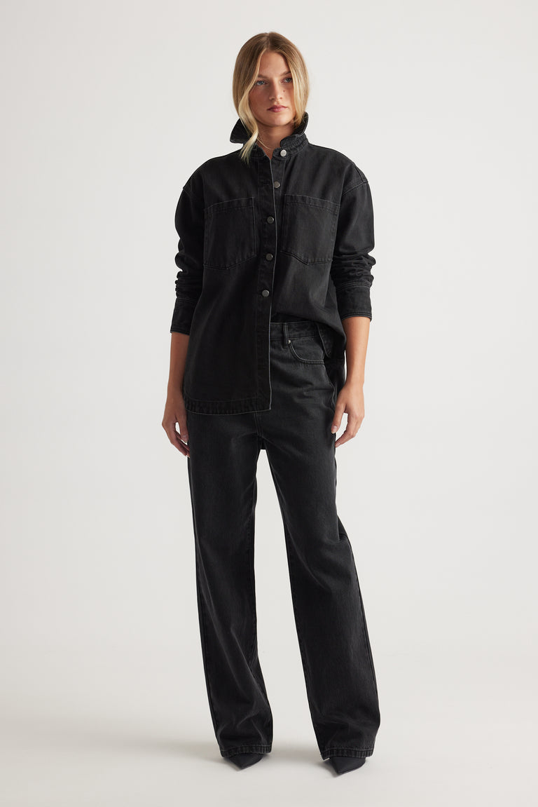 Woman wearing a relaxed black denim shirt with matching wide-leg jeans for a casual, modern look