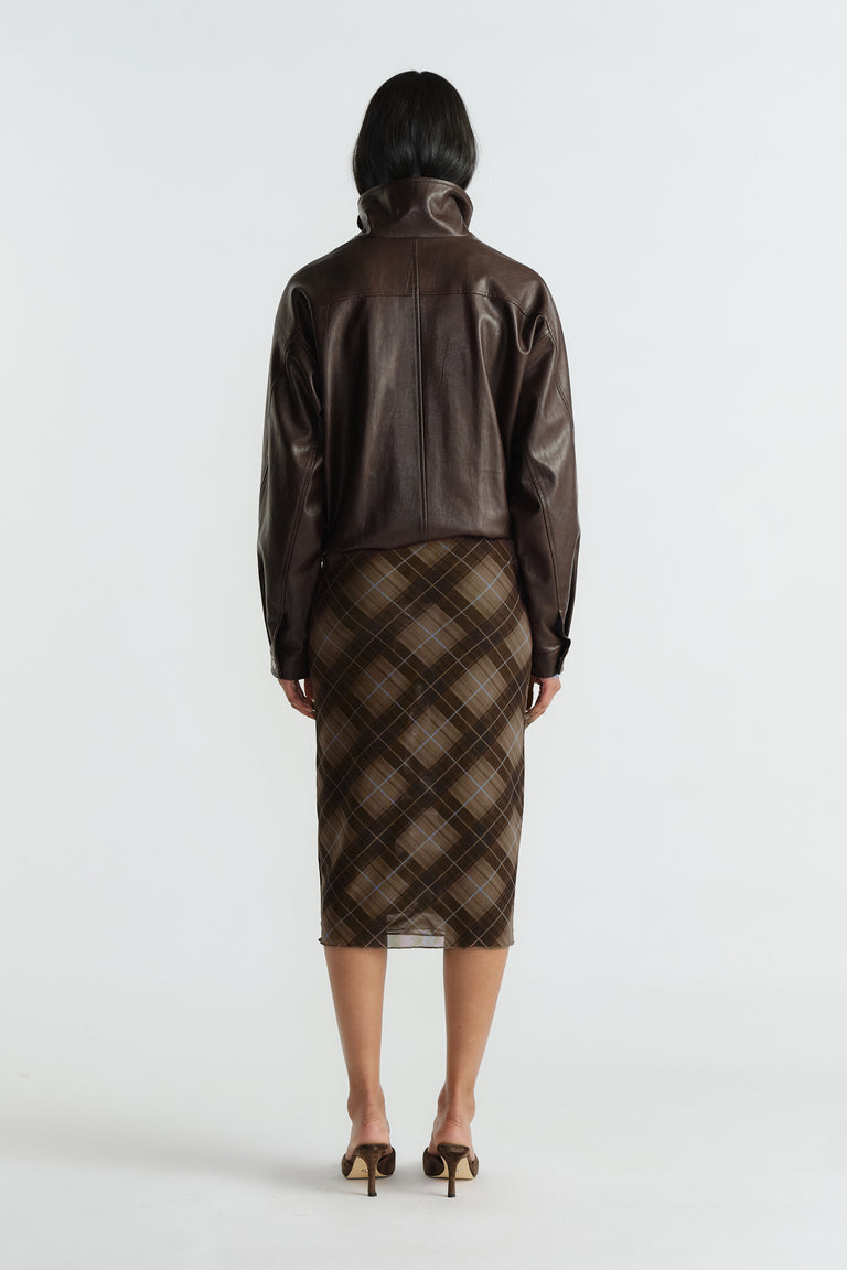 Back view of woman wearing brown plaid mesh skirt paired with a rich chocolate brown leather jacket and heels.
