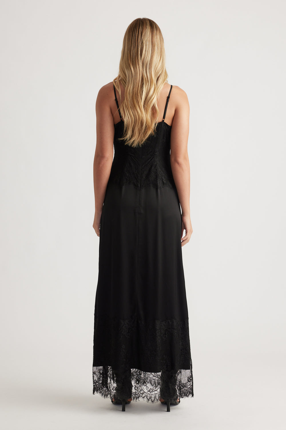 Back view of a black lace maxi dress with delicate lace trim and thin adjustable straps for an elegant silhouette