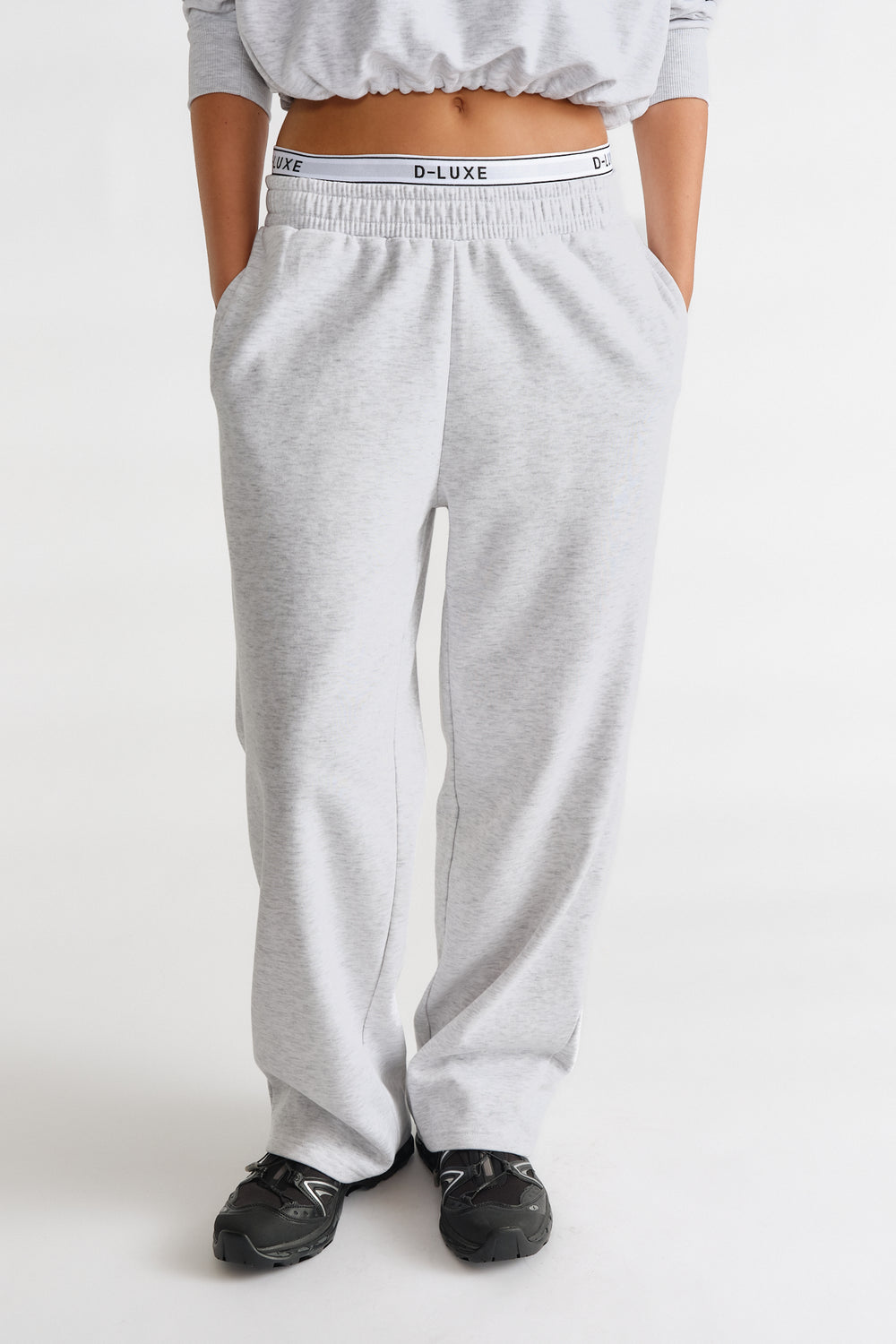 Light grey relaxed-fit track pants with elastic waist featuring a branded D-Luxe logo band for casual comfort.