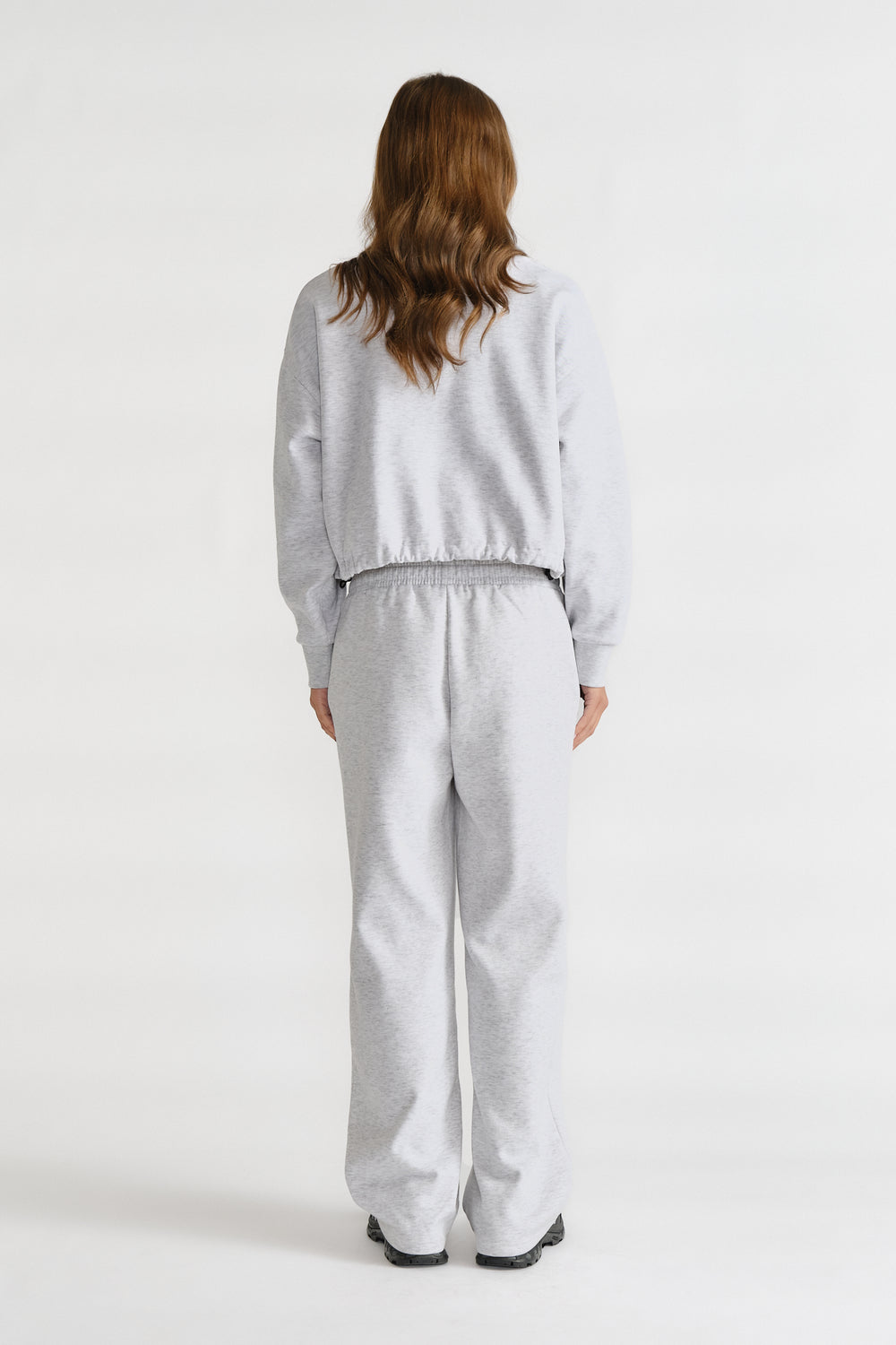 Relaxed fit light grey trackpants with an elastic waistband, styled with a matching casual top for everyday comfort.