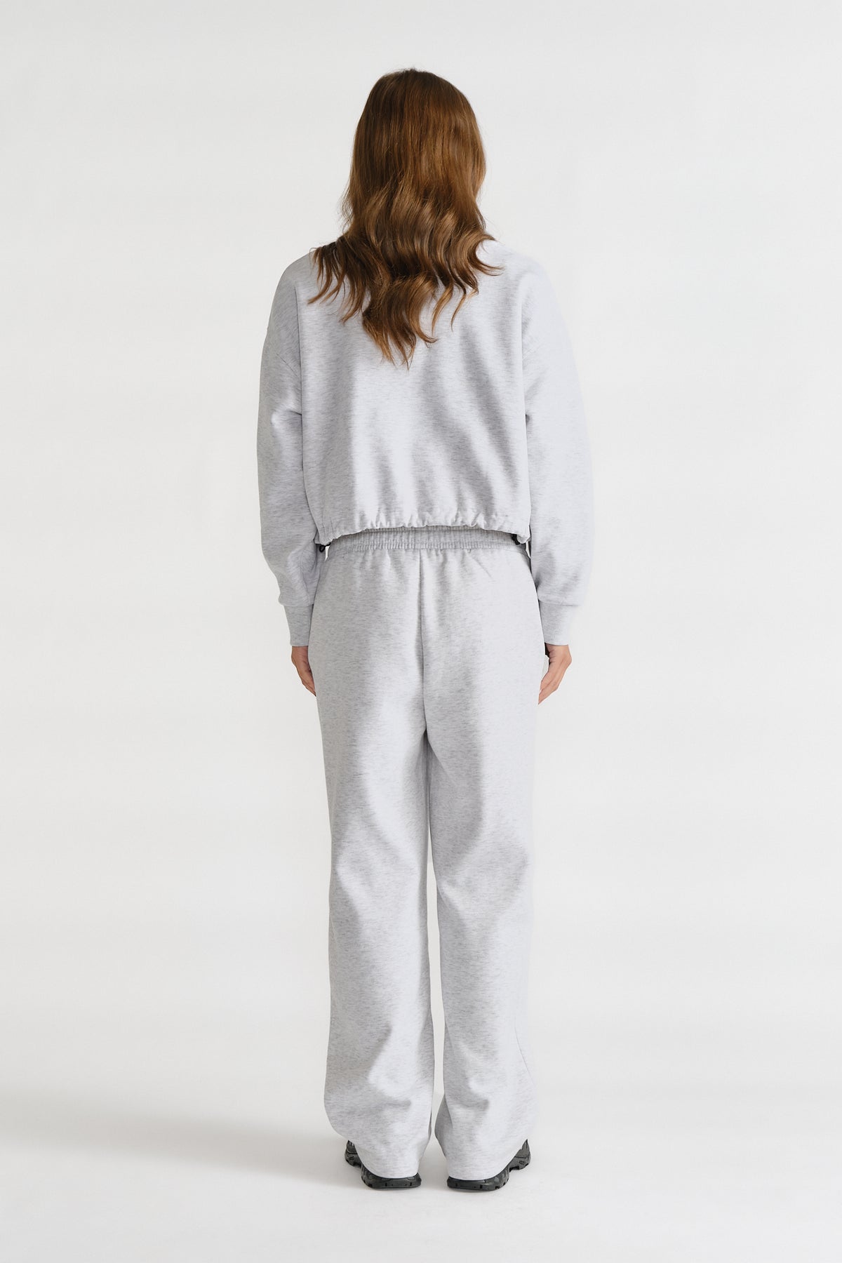 Relaxed fit light grey trackpants with an elastic waistband, styled with a matching casual top for everyday comfort.