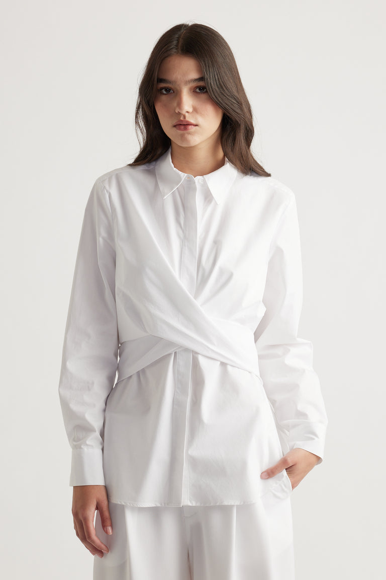 White long-sleeve shirt with a unique wrap detail at the waist, offering a modern, polished silhouette.