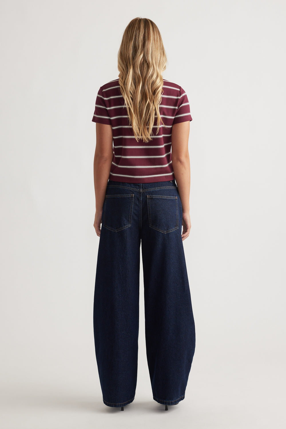 Back view of a plum striped short sleeve tee paired with wide-leg dark denim jeans for a casual look